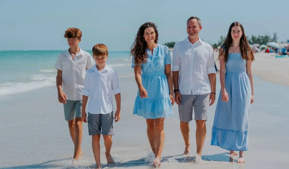 Tracy and her family walking along the beach